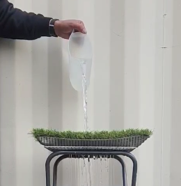 人工芝の排水穴から排水する様子